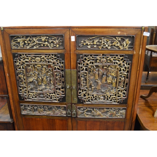 1042 - A CHINESE TWO DOOR CUPBOARD  with carved and gilt decorated panelled doors. 3ft 4ins wide , 5ft 2ins... 