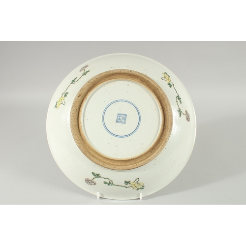 101 - A CHINESE FAMILLE VERTE PORCELAIN DISH, painted with figures in a courtyard scene, 29cm diameter.