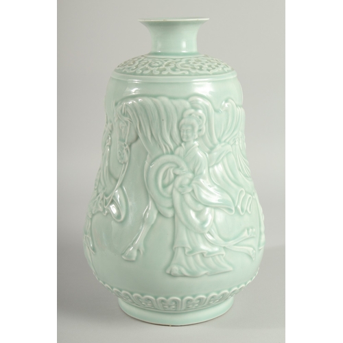 106 - A CHINESE CELADON GLAZE PORCELAIN VASE, the body carved with figures and a horse, 33cm high.