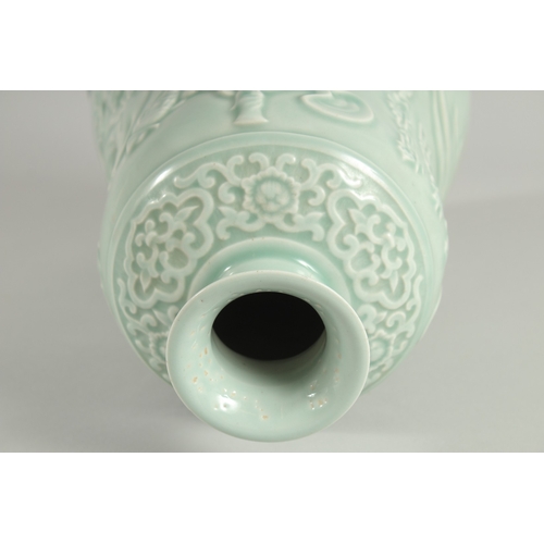 106 - A CHINESE CELADON GLAZE PORCELAIN VASE, the body carved with figures and a horse, 33cm high.