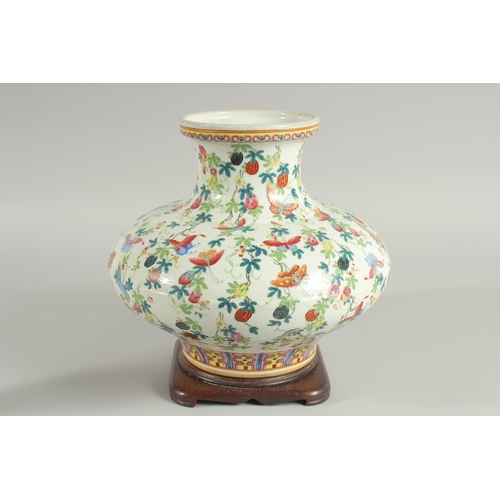 109 - A CHINESE FAMILLE ROSE PORCELAIN SQUAT-FORM VASE and hardwood stand, the vase decorated all over wit... 