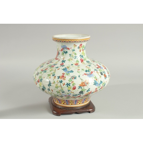 109 - A CHINESE FAMILLE ROSE PORCELAIN SQUAT-FORM VASE and hardwood stand, the vase decorated all over wit... 