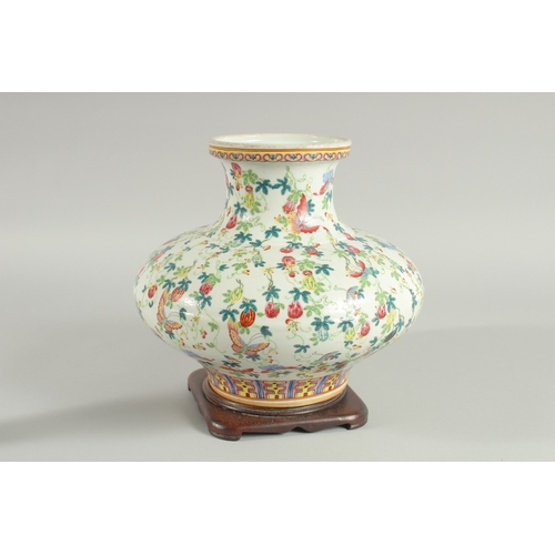 109 - A CHINESE FAMILLE ROSE PORCELAIN SQUAT-FORM VASE and hardwood stand, the vase decorated all over wit... 