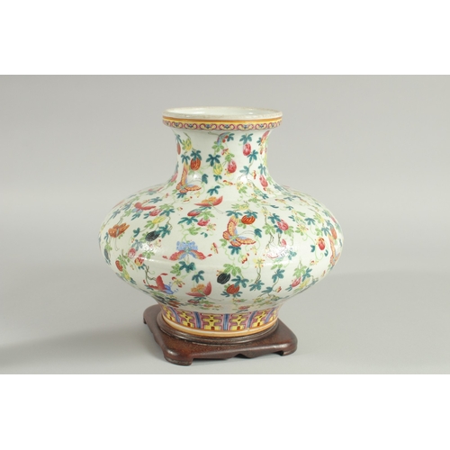 109 - A CHINESE FAMILLE ROSE PORCELAIN SQUAT-FORM VASE and hardwood stand, the vase decorated all over wit... 