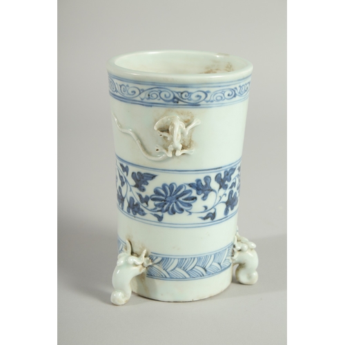 110 - A CHINESE BLUE AND WHITE PORCELAIN BRUSH POT / VASE, with moulded chilong and tripod legs, 15cm high... 