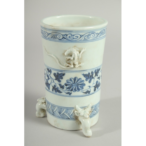 110 - A CHINESE BLUE AND WHITE PORCELAIN BRUSH POT / VASE, with moulded chilong and tripod legs, 15cm high... 