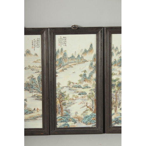 130 - FOUR CHINESE FAMILLE VERTE PORCELAIN PANELS, inset within wooden frames, each depicting mountainous ... 