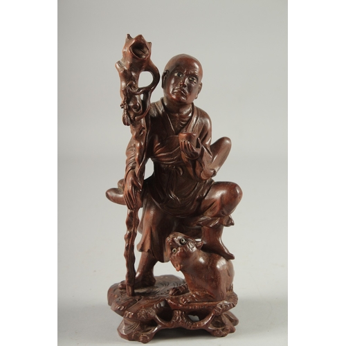 143 - A CHINESE CARVED HARDWOOD FIGURE, 25.5cm high.