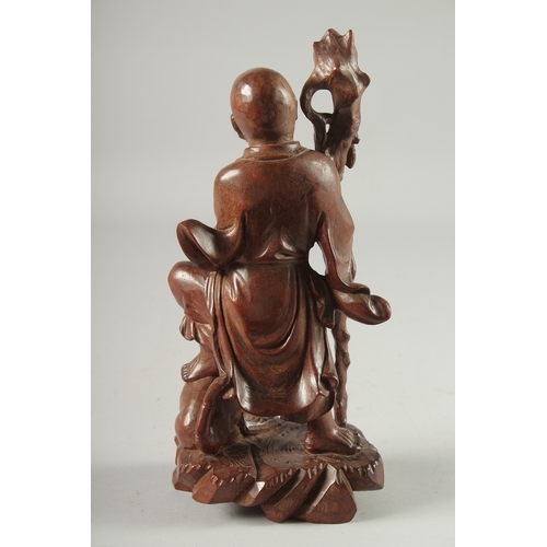 143 - A CHINESE CARVED HARDWOOD FIGURE, 25.5cm high.