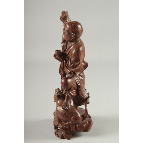 143 - A CHINESE CARVED HARDWOOD FIGURE, 25.5cm high.