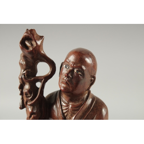 143 - A CHINESE CARVED HARDWOOD FIGURE, 25.5cm high.