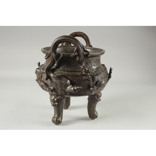 146 - A LARGE CHINESE BRONZE TWIN HANDLE TRIPOD CENSER, with relief horses and sea creatures, the handles ... 