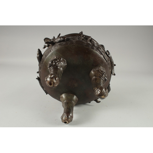 146 - A LARGE CHINESE BRONZE TWIN HANDLE TRIPOD CENSER, with relief horses and sea creatures, the handles ... 