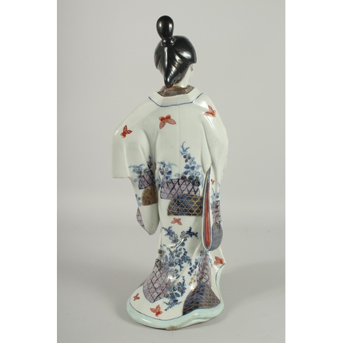 164 - A FINE AND LARGE JAPANESE ARITA PORCELAIN BIJIN, the robe painted with blue and white patterns and r... 