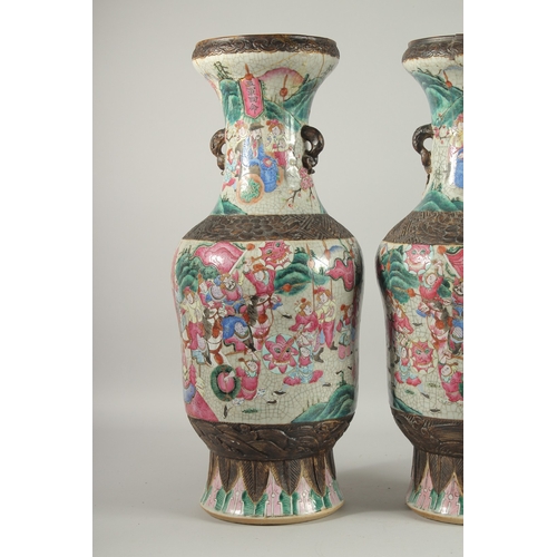 183 - A LARGE PAIR OF CHINESE FAMILLE ROSE PORCELAIN VASES, with moulded twin handles, each painted with a... 