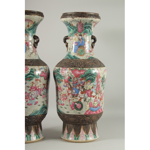 183 - A LARGE PAIR OF CHINESE FAMILLE ROSE PORCELAIN VASES, with moulded twin handles, each painted with a... 