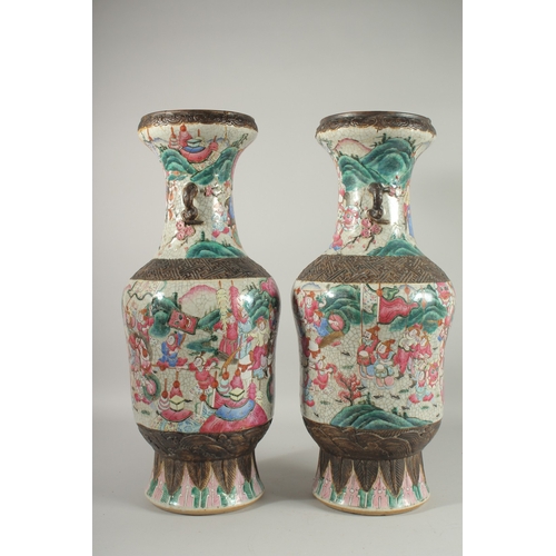 183 - A LARGE PAIR OF CHINESE FAMILLE ROSE PORCELAIN VASES, with moulded twin handles, each painted with a... 