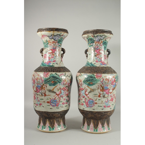 183 - A LARGE PAIR OF CHINESE FAMILLE ROSE PORCELAIN VASES, with moulded twin handles, each painted with a... 