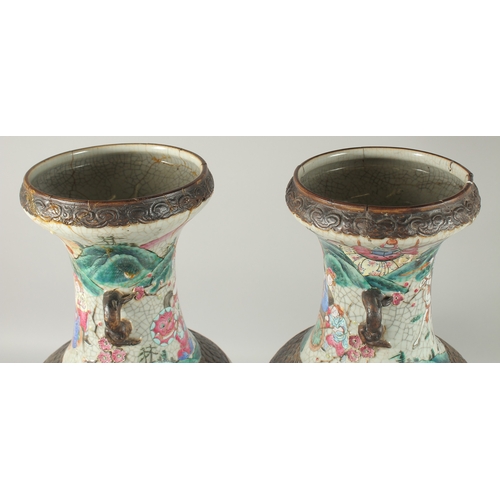 183 - A LARGE PAIR OF CHINESE FAMILLE ROSE PORCELAIN VASES, with moulded twin handles, each painted with a... 