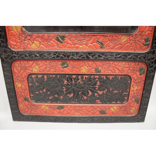 185 - A LARGE 19TH CENTURY CHINESE CARVED BLACK AND RED CINNABAR LACQUER PANEL, depicting two male figures... 