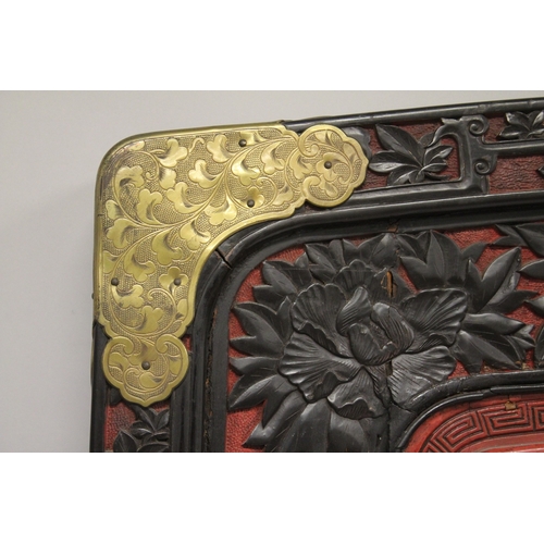 185 - A LARGE 19TH CENTURY CHINESE CARVED BLACK AND RED CINNABAR LACQUER PANEL, depicting two male figures... 