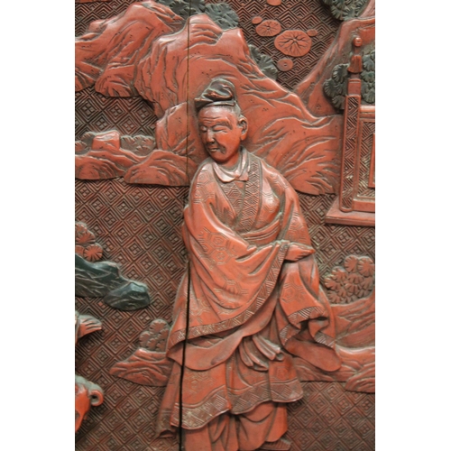 185 - A LARGE 19TH CENTURY CHINESE CARVED BLACK AND RED CINNABAR LACQUER PANEL, depicting two male figures... 