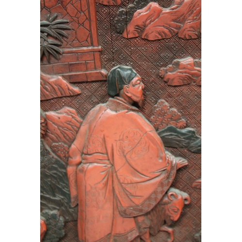 185 - A LARGE 19TH CENTURY CHINESE CARVED BLACK AND RED CINNABAR LACQUER PANEL, depicting two male figures... 