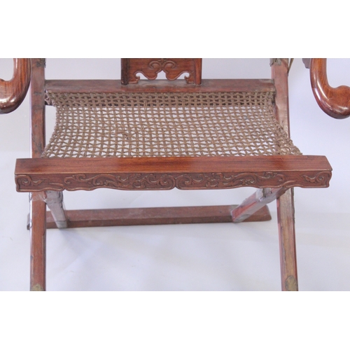 187 - A CHINESE HARDWOOD HORSESHOE-BACK FOLDING CHAIR, with carved and pierced kylin panel and netted seat... 