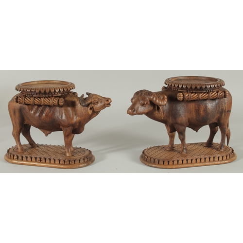 224 - TWO FINE 19TH CENTURY ANGLO INDIAN CARVED WOODEN BUFFALO SHAPED COASTERS / STANDS, each approx. 24cm... 