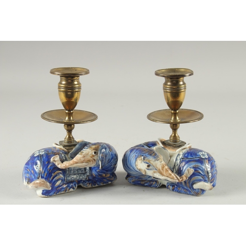 3 - A PAIR OF BLUE AND WHITE PORCELAIN BRASS MOUNTED FIGURAL CANDLESTICKS, the porcelain bases formed as... 