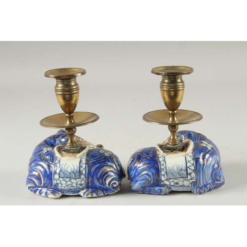 3 - A PAIR OF BLUE AND WHITE PORCELAIN BRASS MOUNTED FIGURAL CANDLESTICKS, the porcelain bases formed as... 