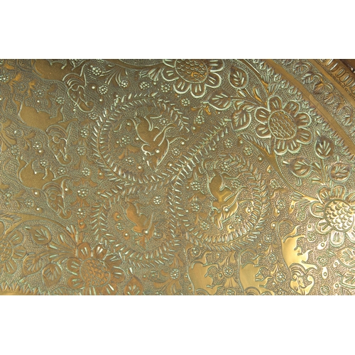 301 - A 19TH CENTURY INDIAN ENGRAVED BRASS TRAY INSET WITHIN A VELVET OVERLAID WOODEN FRAME, beautifully e... 