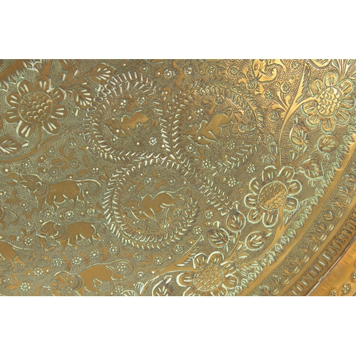 301 - A 19TH CENTURY INDIAN ENGRAVED BRASS TRAY INSET WITHIN A VELVET OVERLAID WOODEN FRAME, beautifully e... 