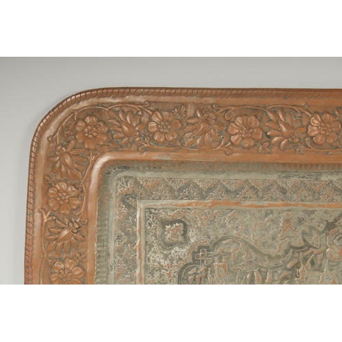 302 - A VERY LARGE PERSIAN ISFAHAN EMBOSSED AND CHASED TINNED COPPER RECTANGULAR TRAY, with a central reli... 