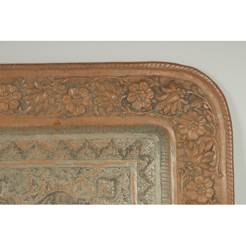 302 - A VERY LARGE PERSIAN ISFAHAN EMBOSSED AND CHASED TINNED COPPER RECTANGULAR TRAY, with a central reli... 