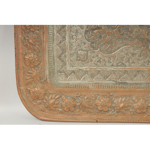 302 - A VERY LARGE PERSIAN ISFAHAN EMBOSSED AND CHASED TINNED COPPER RECTANGULAR TRAY, with a central reli... 