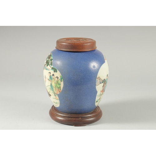 36 - AN EARLY 20TH CENTURY CHINESE BLUE GROUND FAMILLE VERTE PORCELAIN JAR, with wooden cover and stand.