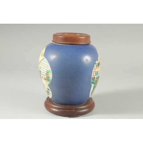 36 - AN EARLY 20TH CENTURY CHINESE BLUE GROUND FAMILLE VERTE PORCELAIN JAR, with wooden cover and stand.