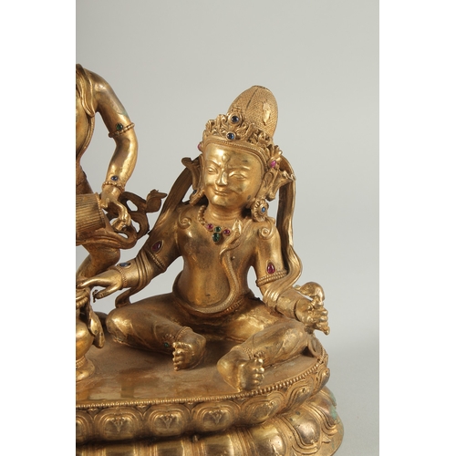 42 - A LARGE GILT BRONZE FIGURE OF TWO DEITIES ON AN OVAL DOUBLE-LOTUS BASE, 28cm wide.