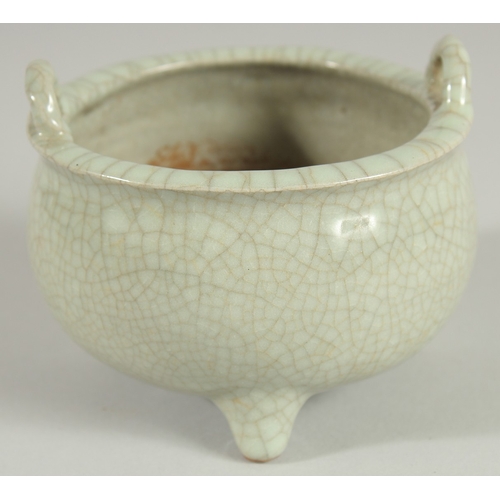 44 - A CHINESE CELADON CRACKLE GLAZE TWIN HANDLE TRIPOD CENSER, 10.5cm diameter.