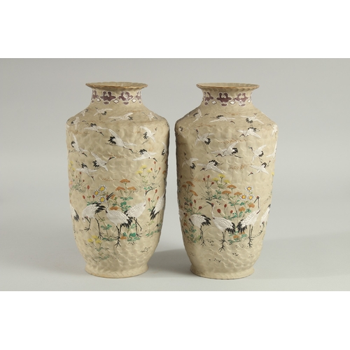 5 - AN UNUSUAL PAIR OF JAPANESE POTTERY VASES, with enamel painted decoration of cranes and flora, inscr... 