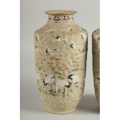 5 - AN UNUSUAL PAIR OF JAPANESE POTTERY VASES, with enamel painted decoration of cranes and flora, inscr... 