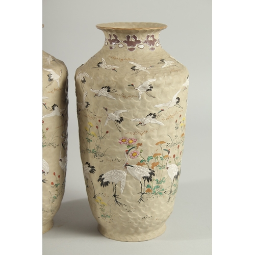 5 - AN UNUSUAL PAIR OF JAPANESE POTTERY VASES, with enamel painted decoration of cranes and flora, inscr... 