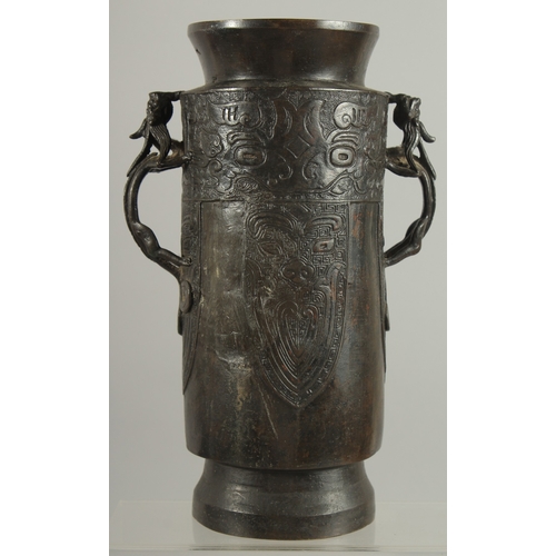 90 - A CHINESE BRONZE VASE WITH TWIN CHILONG HANDLES, with archaic style mask decoration, 28cm high.