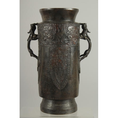 90 - A CHINESE BRONZE VASE WITH TWIN CHILONG HANDLES, with archaic style mask decoration, 28cm high.