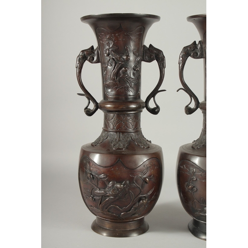 93 - A LARGE PAIR OF JAPANESE BRONZE TWIN HANDLE VASES, with relief decoration depicting birds on branche... 