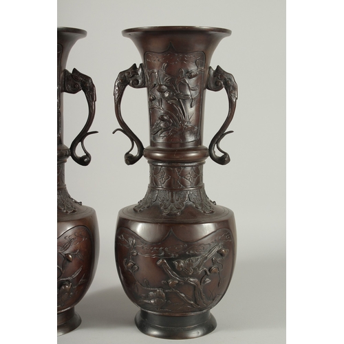 93 - A LARGE PAIR OF JAPANESE BRONZE TWIN HANDLE VASES, with relief decoration depicting birds on branche... 