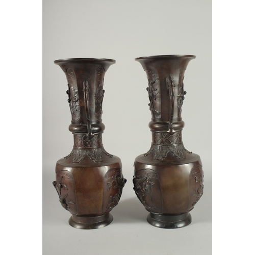 93 - A LARGE PAIR OF JAPANESE BRONZE TWIN HANDLE VASES, with relief decoration depicting birds on branche... 