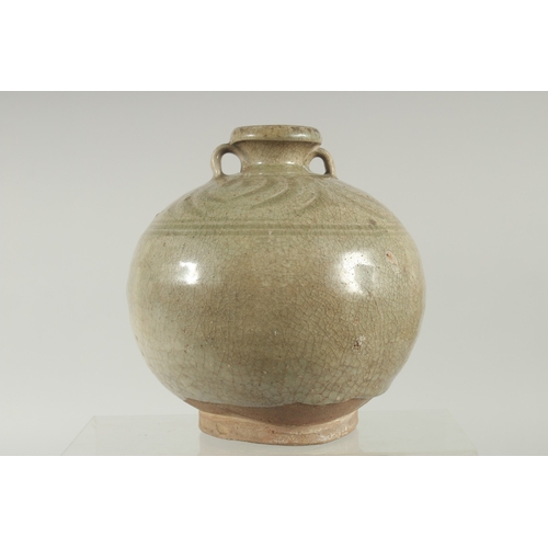 94 - A CELADON GLAZED POTTERY TWIN HANDLE BOTTLE / VASE, with carved decoration to the shoulder, 16cm hig... 