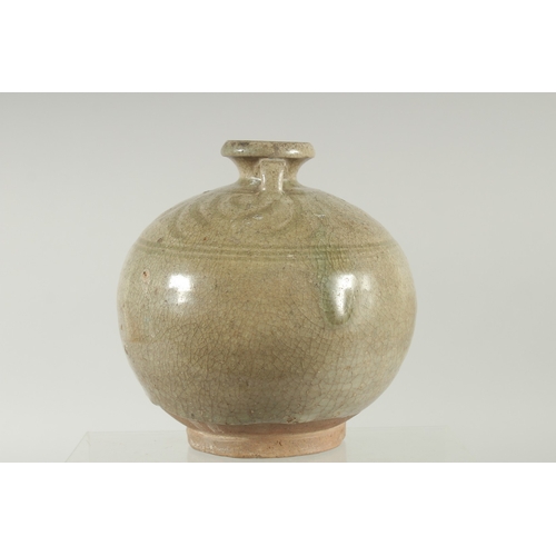 94 - A CELADON GLAZED POTTERY TWIN HANDLE BOTTLE / VASE, with carved decoration to the shoulder, 16cm hig... 